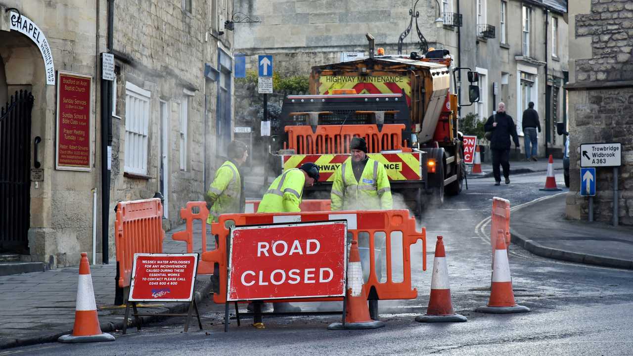 Road workers repairing road surface in Bradford on Avon UK town centre