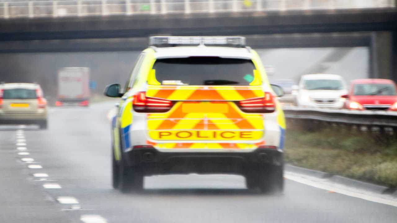 British police vehicle speeding down motorway