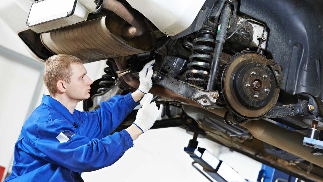 Car mechanic inspecting rear suspension