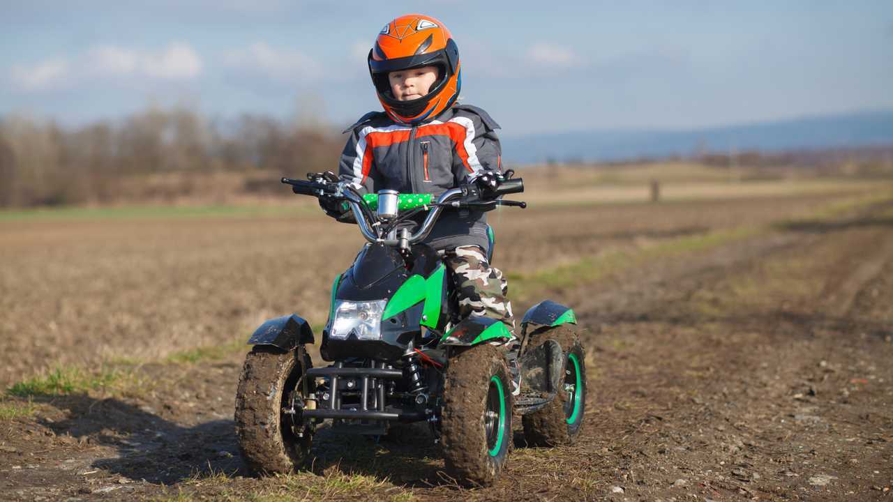 Little boy rides his electric ATV quad bike