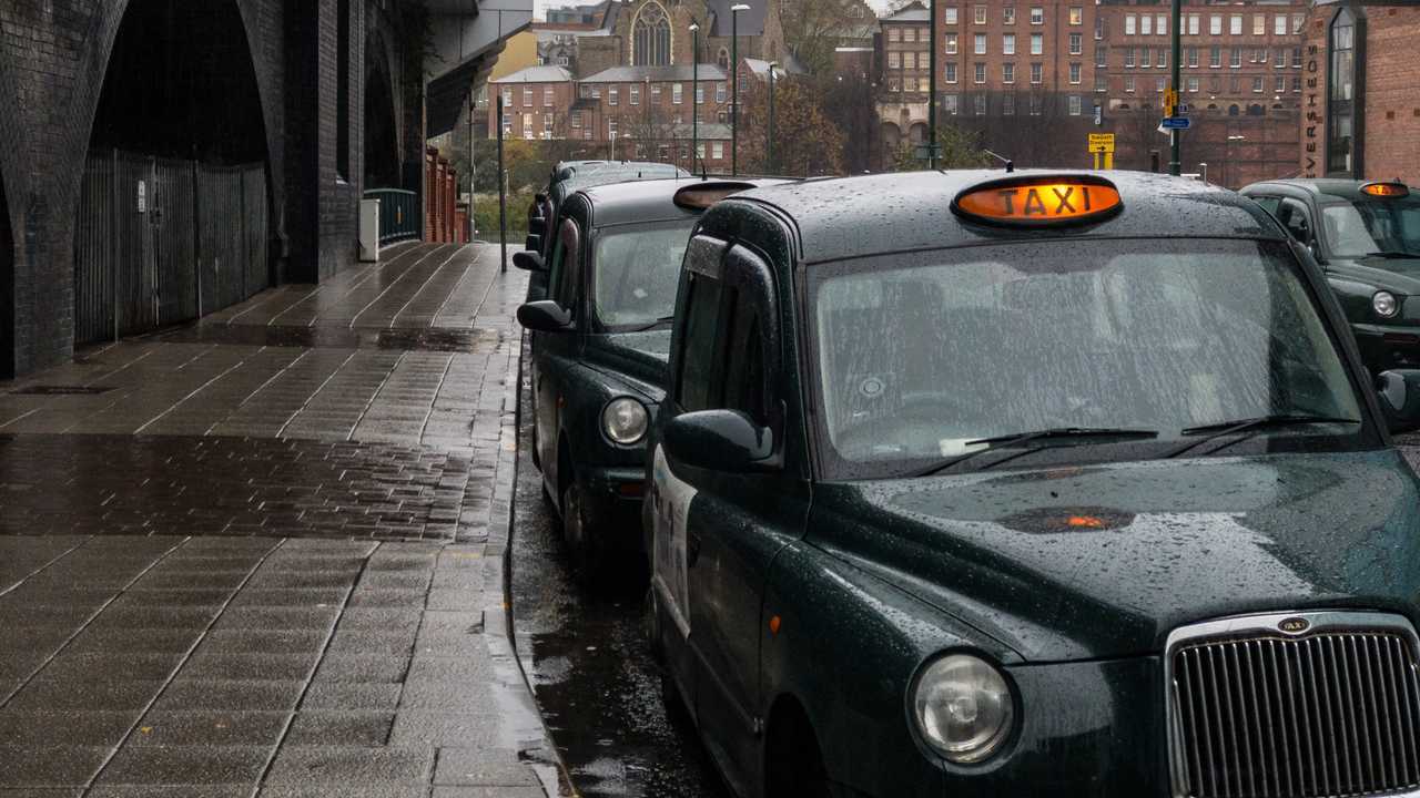 Row of green taxi cabs in Nottingham UK