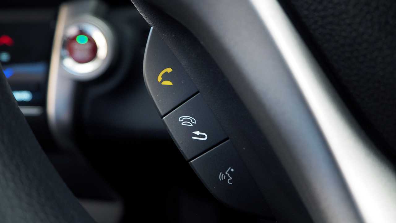 Close up of yellow phone sign on car steering wheel