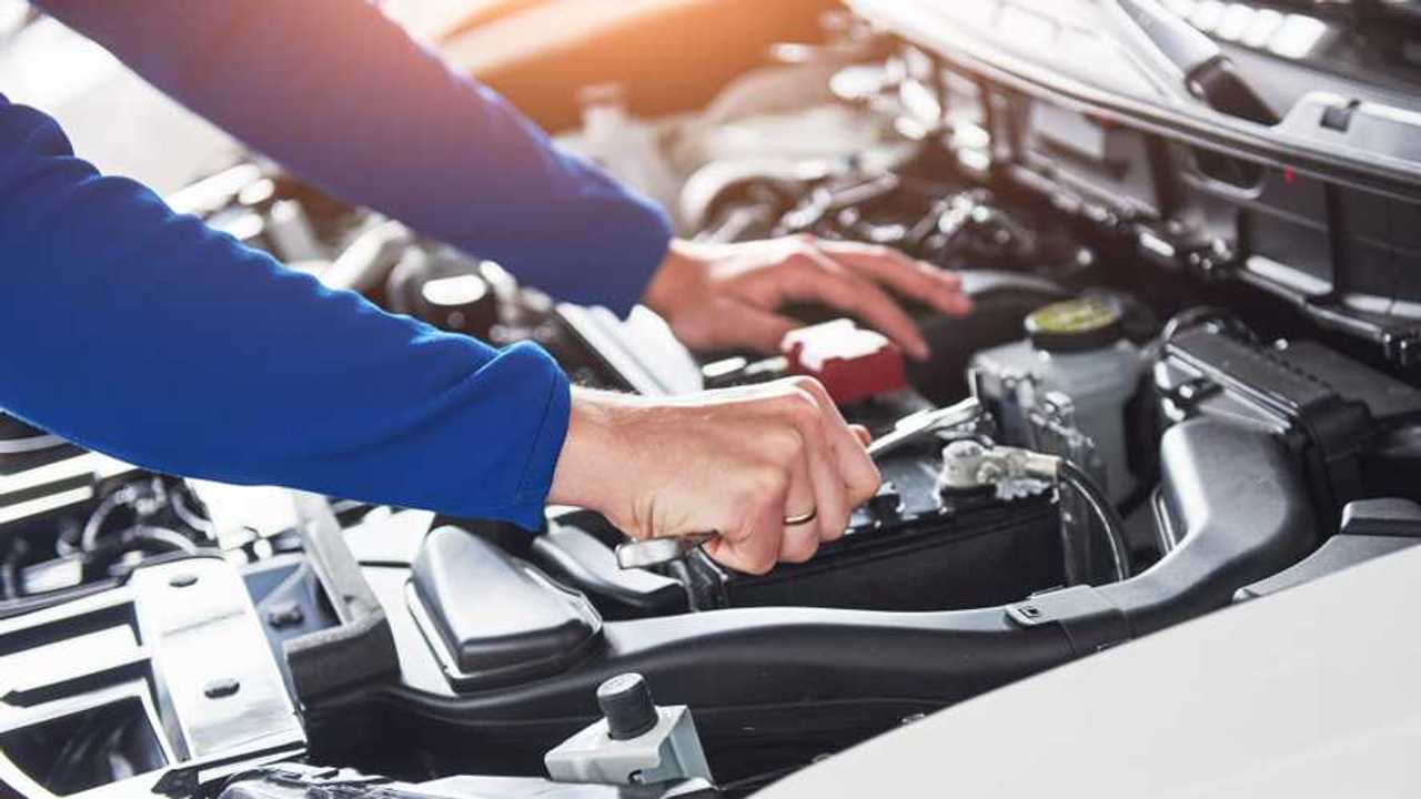 Car mechanic with wrench on car in garage