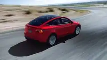Una Model Y rossa di tre quarti posteriore