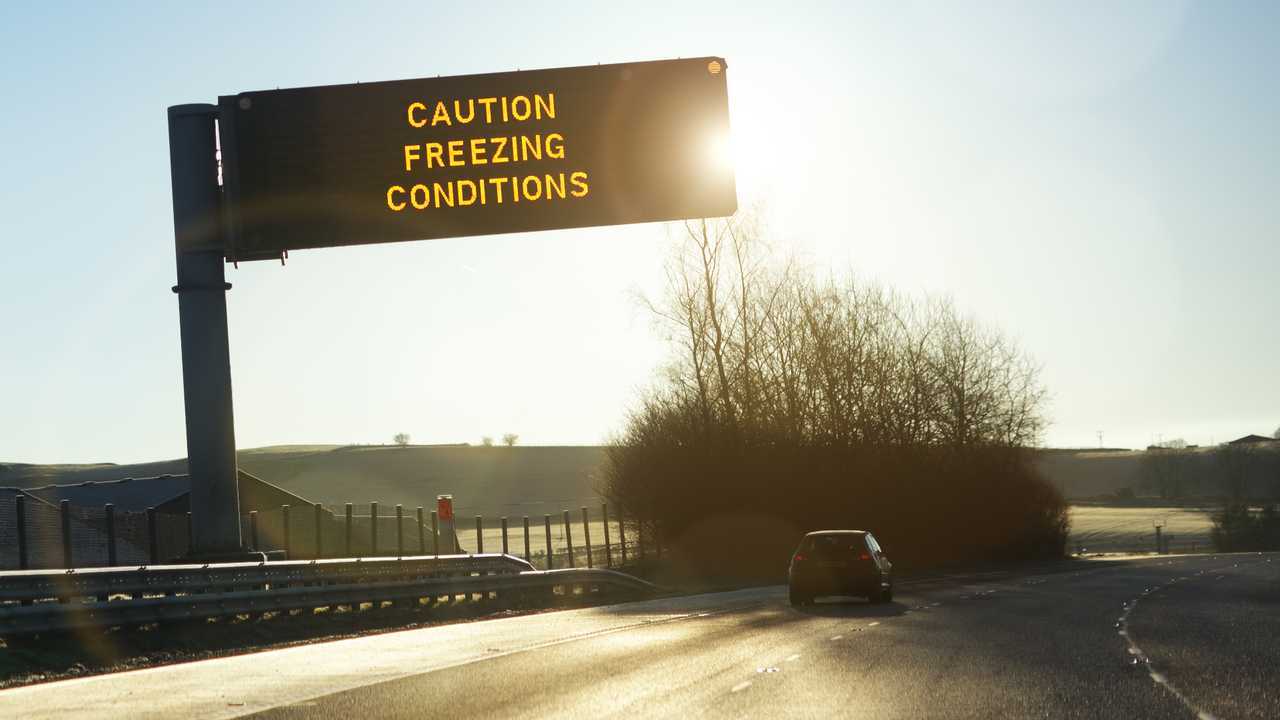 Motorway gantry sign reading caution freezing conditions