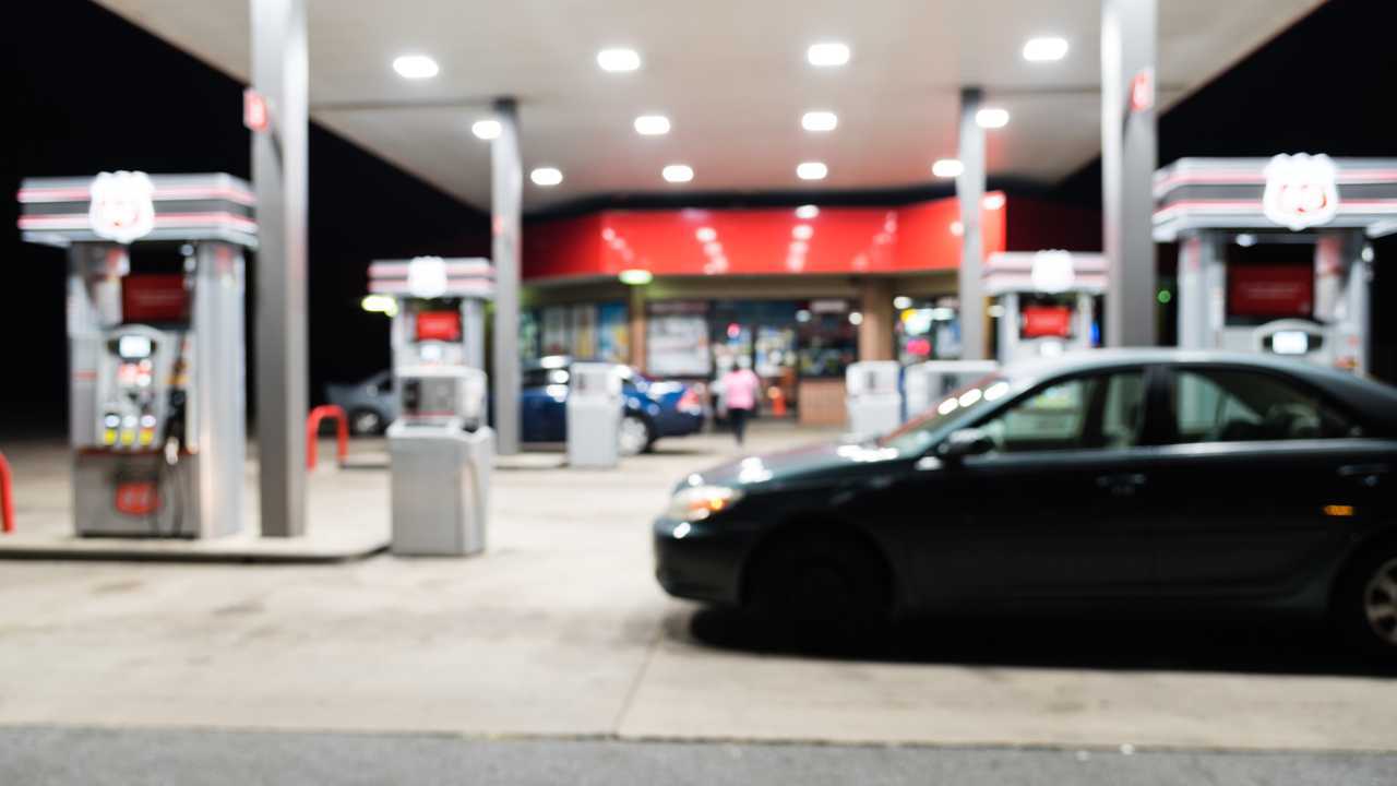 Petrol station with car refuelling at night