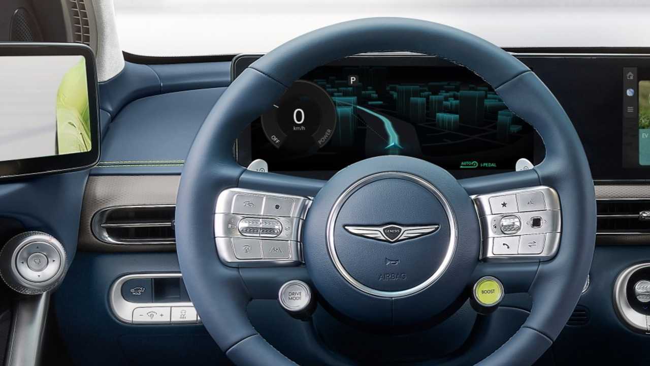 Genesis GV60: Lenkrad mit Boost-Knopf und Drive Mode-Knopf, das Instrumentendisplay und die Außenspiegelverstellung (links)