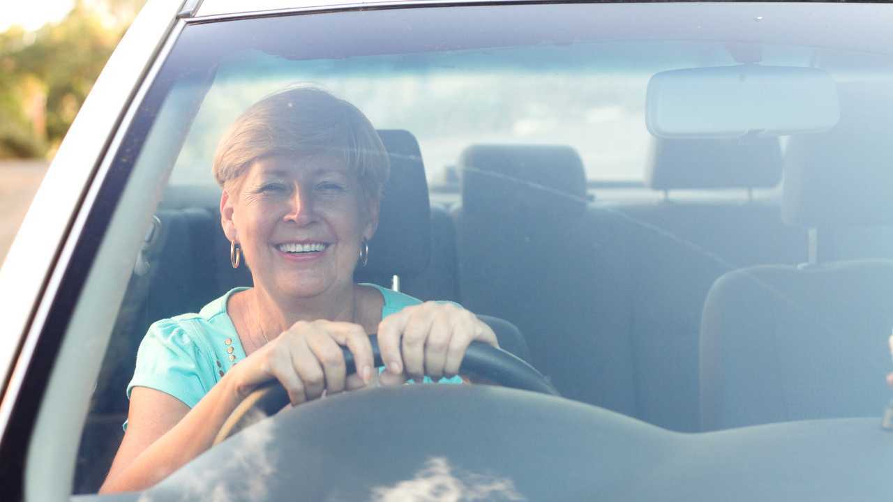 Happy senior woman driving a car