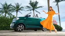 Wuling Hong Guang Mini EV Cabrio exterior with woman posing alongside