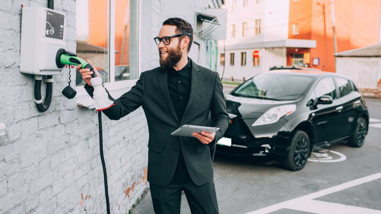 Man is charging Nissan Leaf electric car