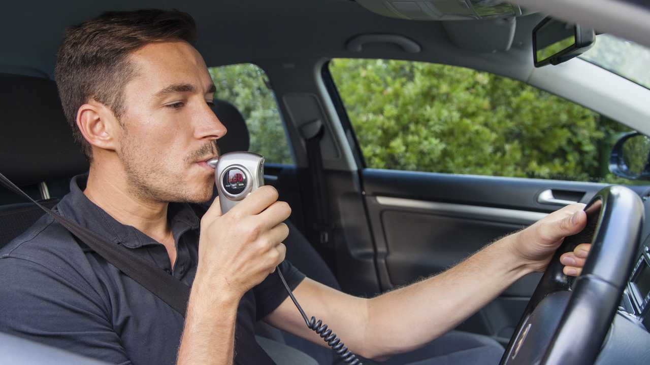 Man in car blowing into breathalyser