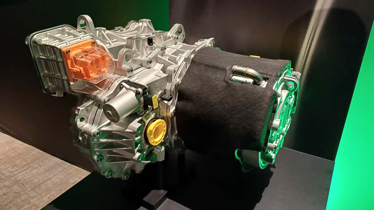 Kia EV3 (2025): Der Antrieb mit Elektromotor (rechts, mit Thermoisolierung), Getriebe (mit gelbem Abtriebs-Marker und Inverter (senkrecht an der hinteren Seite, kaum zu sehen)