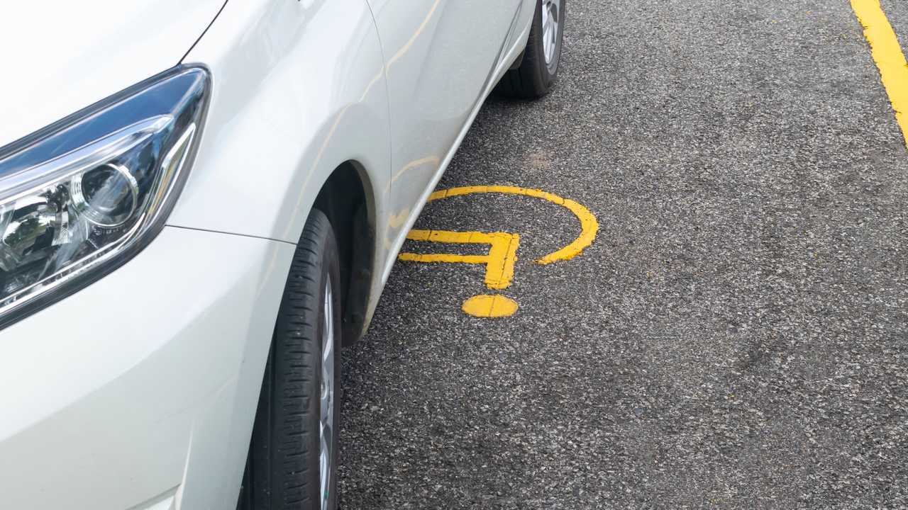 Car parked on handicapped parking sign
