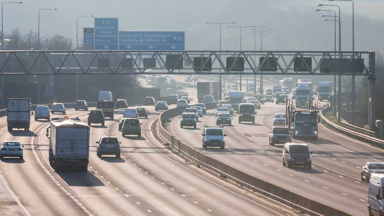 Busiest British motorway M25 with cars and lorries in a foggy sunset time in London