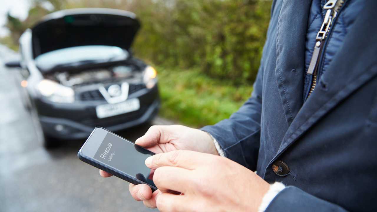 Motorist broken down on country road phoning for help