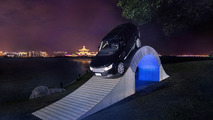 Range Rover driving over a paper bridge