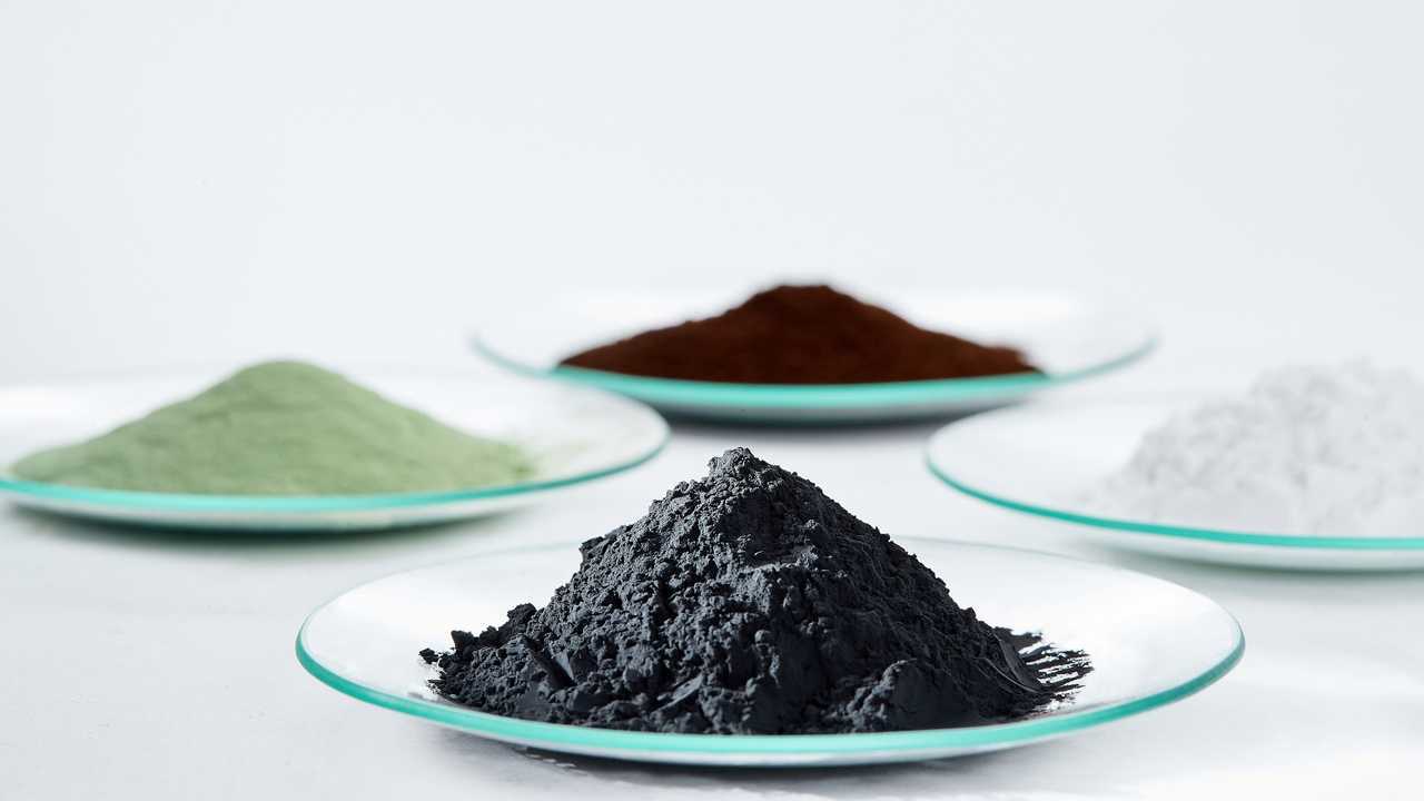 BASF-Batterierohstoffe: Vorläufer-Kathodenmaterial (grünes und braunes Pulver), Lithiumcarbonat (weißes Pulver) und Kathodenmaterial (schwarzes Pulver).