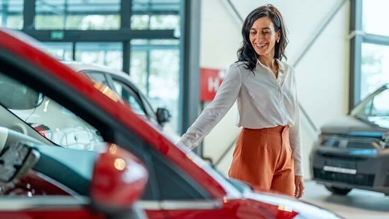 A woman shopping for a car at a dealership.