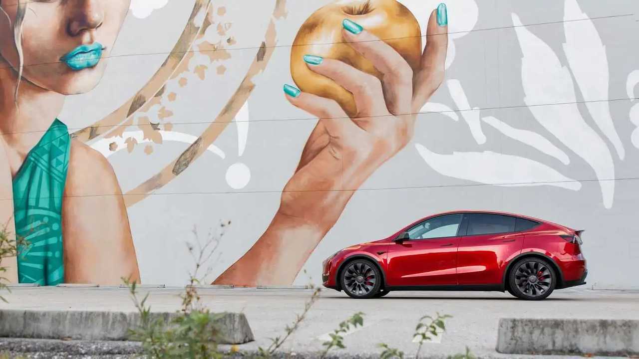 Tesla Model Y in front of graffiti art