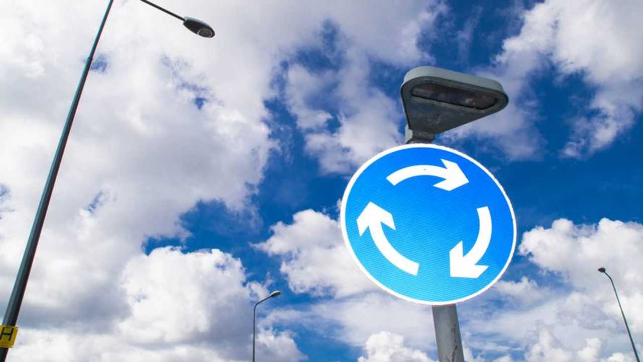 Roundabout street sign with blue cloudy skies