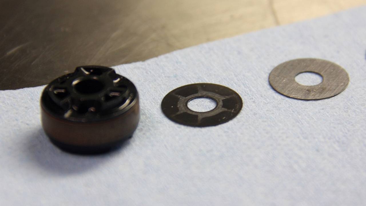 The shim at center exhibits some of the mild surface corrosion that can alter flexion properties. This shim was replaced.
