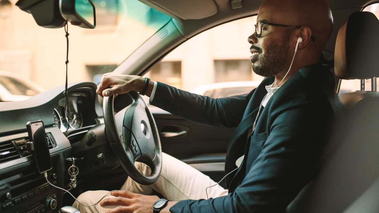 Man listening music with headphones while driving car