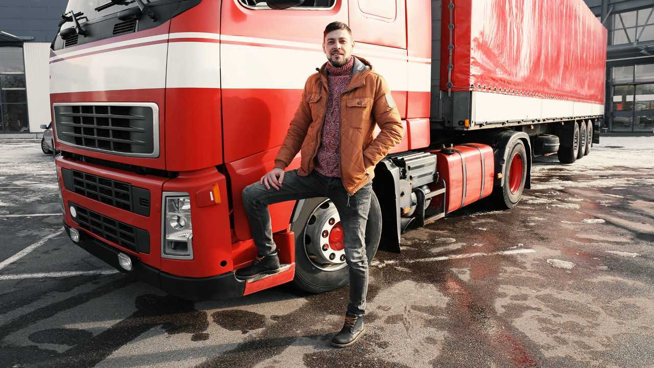 Young man standing with lorry