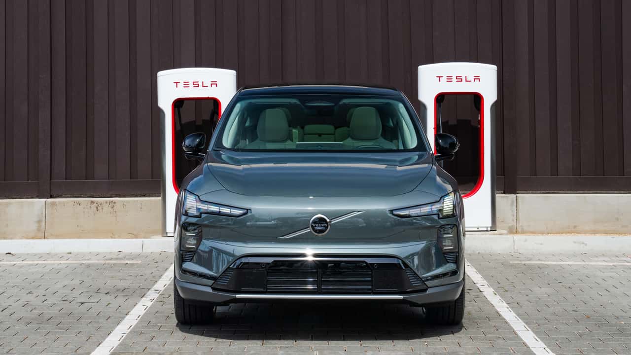 A Volvo EX60 at a Tesla Supercharger