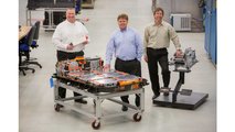 Greg Smith, Engineering Group Manager, Electrification, left, Tim Grewe, General Director, Electrification, center, and Stephen Poulos, Global Chief Engineer, Electrification, right, pose with a Chevrolet Bolt EV battery pack and drive unit in General Motors Global Battery Systems Laboratory at the GM Technical Center in Warren, Michigan, Tuesday, April 5, 2016. (Photo by Jeffrey Sauger for Genera