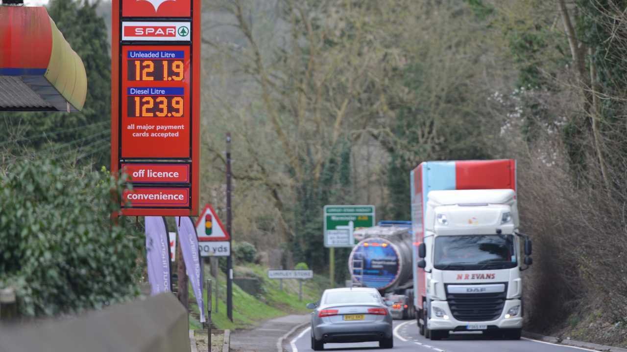 Fuel price sign at petrol station as traffic passes in Bath UK
