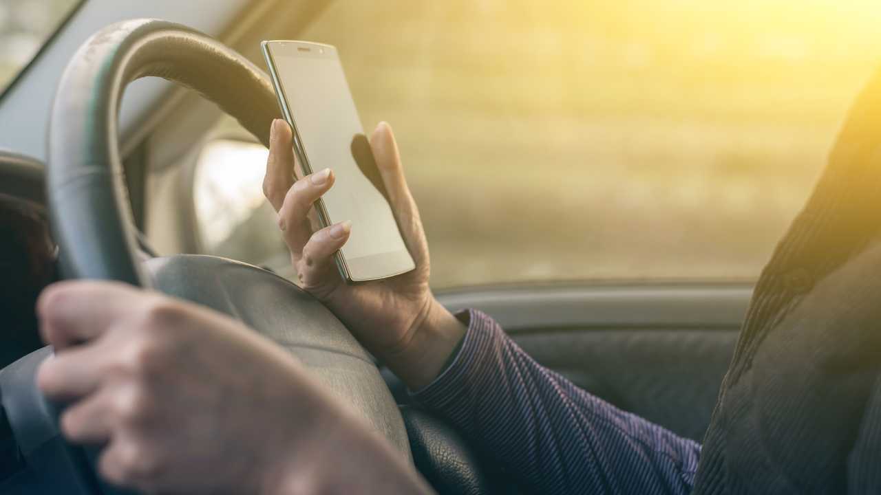 Driver with a mobile phone in hand while driving