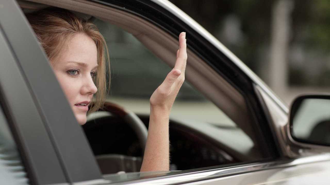 Annoyed young woman driver gesturing with hands