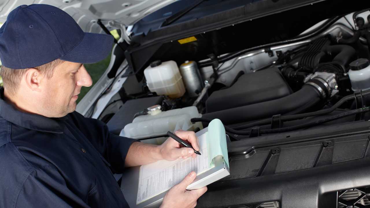 Mechanic inspecting car in service garage