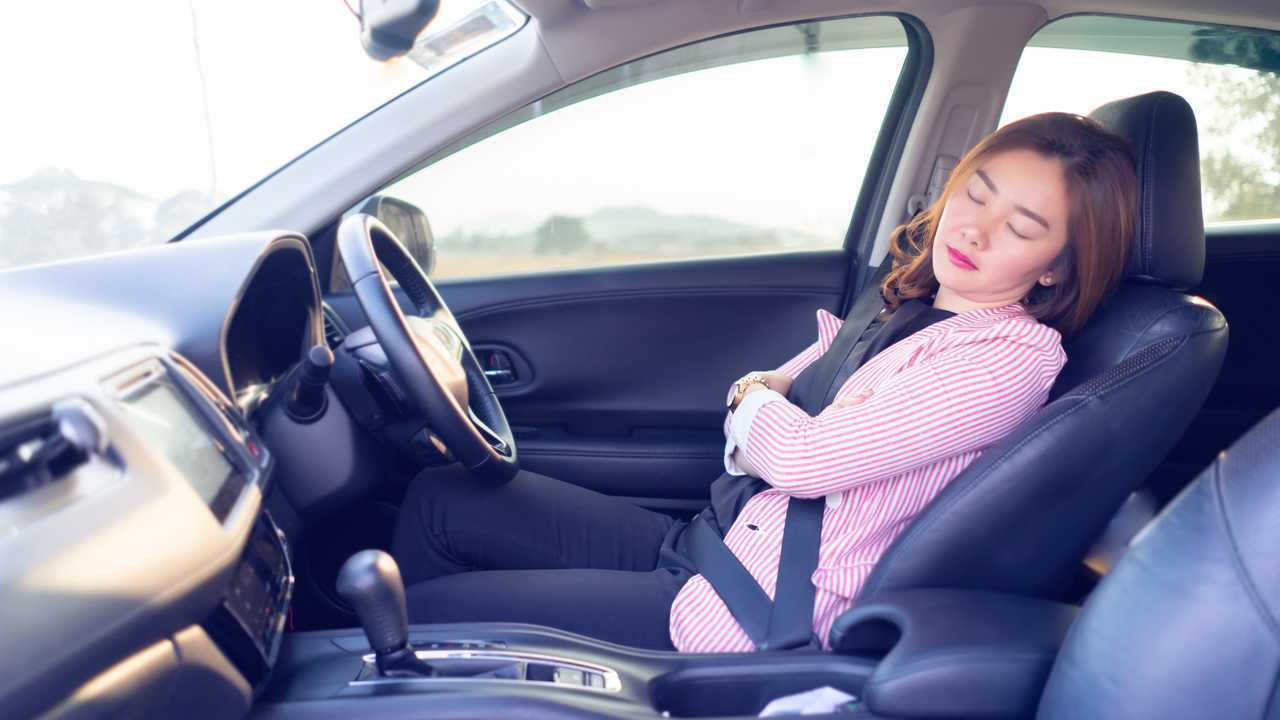 Tired women with seat reclined sleeping in car