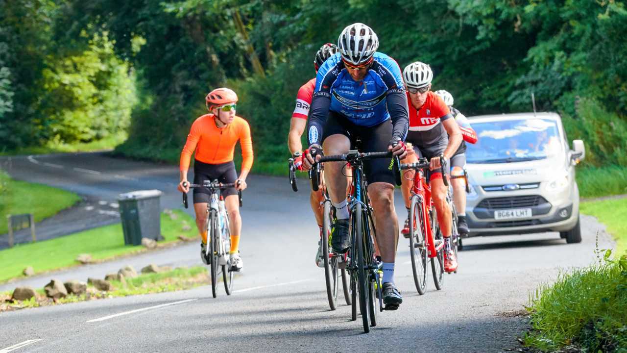 Group of cyclists and their support car in Northumberland UK