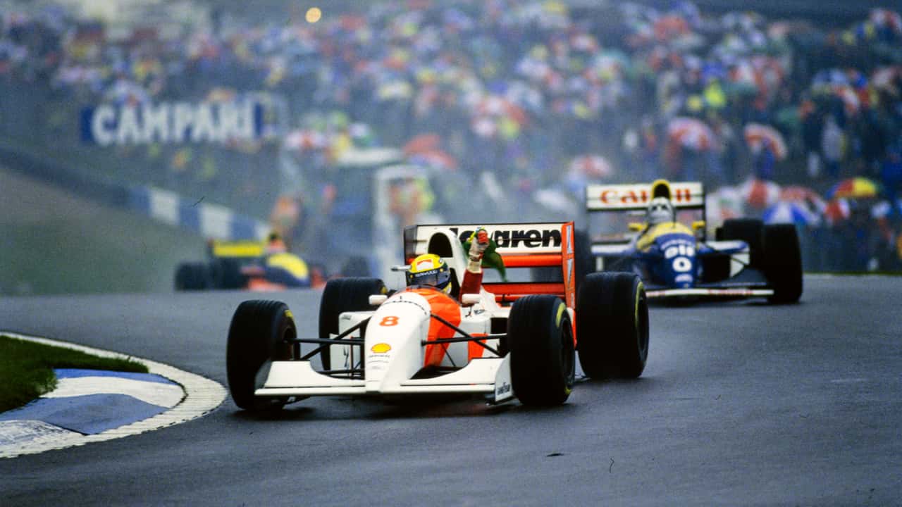 Ayrton Senna, McLaren MP4-8 Ford, agite un drapeau brésilien en signe de célébration devant Damon Hill, Williams FW15C Renault.