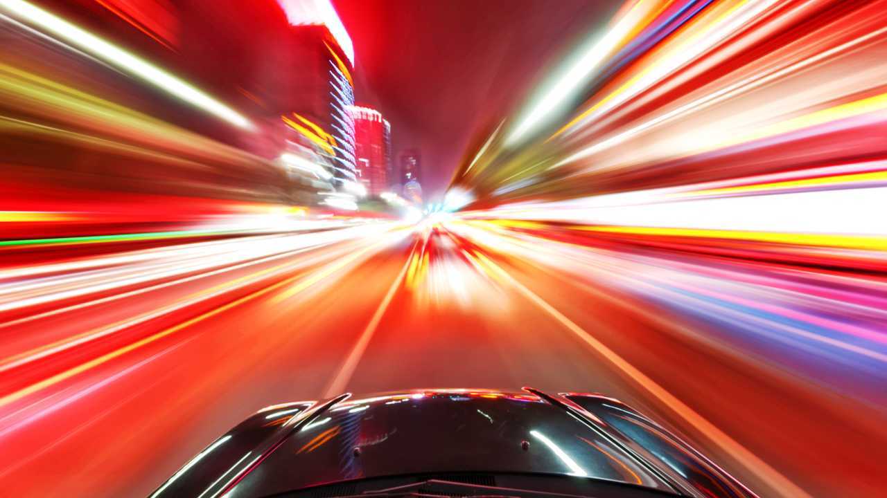Car driving on a motorway at high speeds overtaking other cars