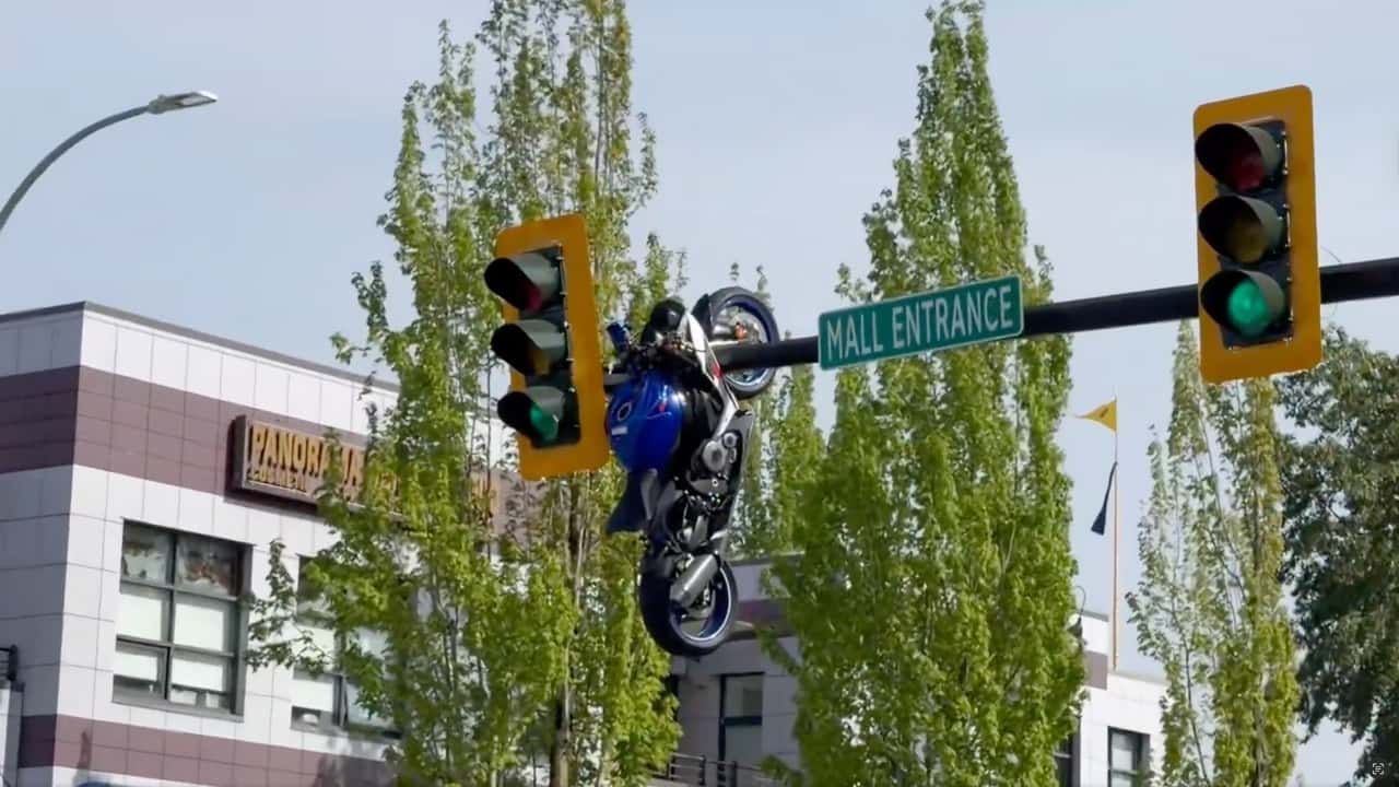 Motorcycle Dangling From Traffic Light Pole