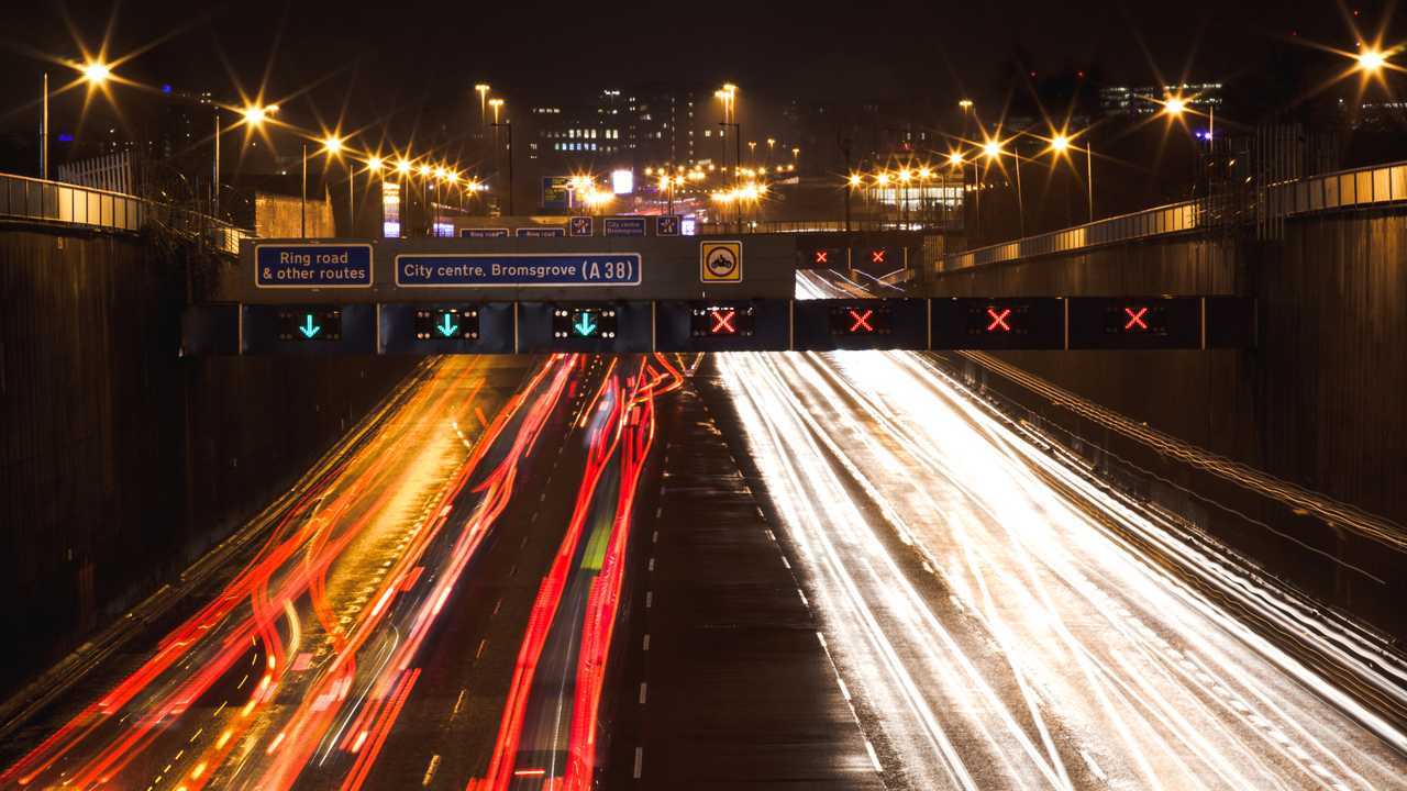 Cars driving down motorway into Birmingham UK at night