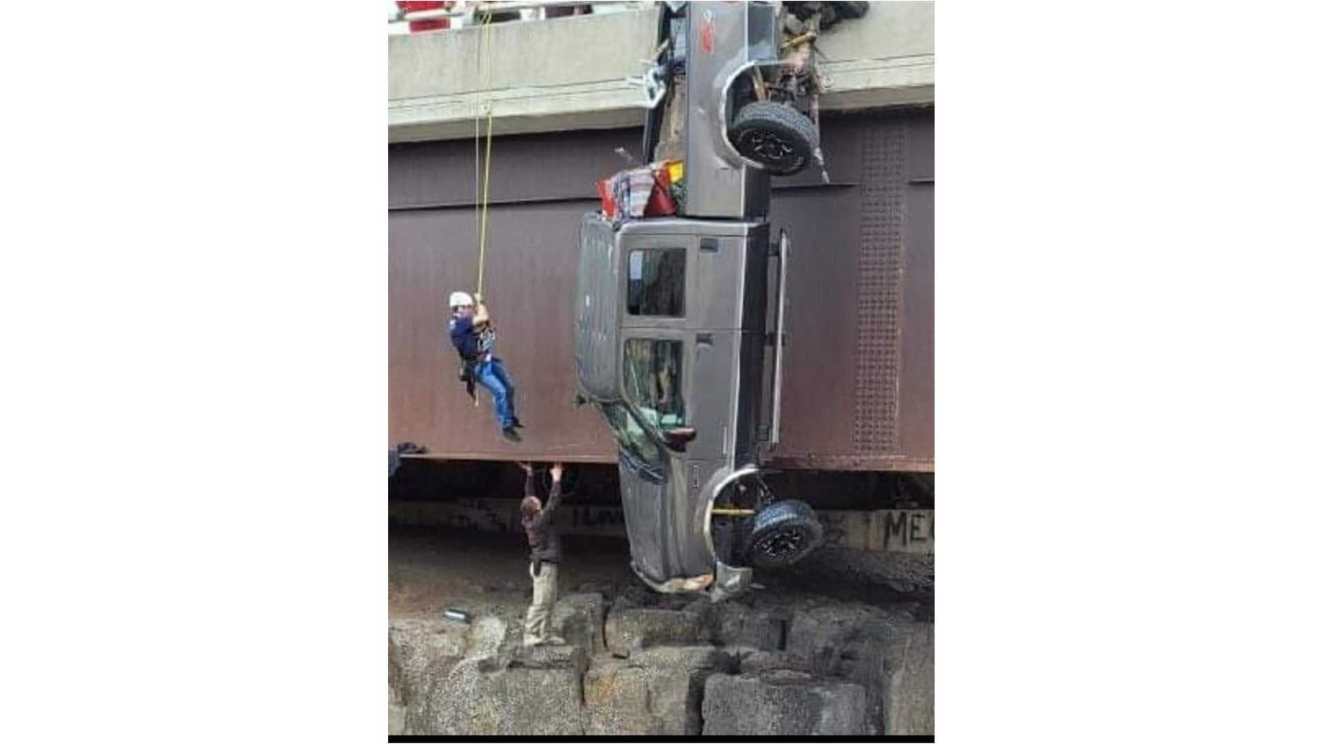 Rescuers save people in truck dangling by safety chains from bridge