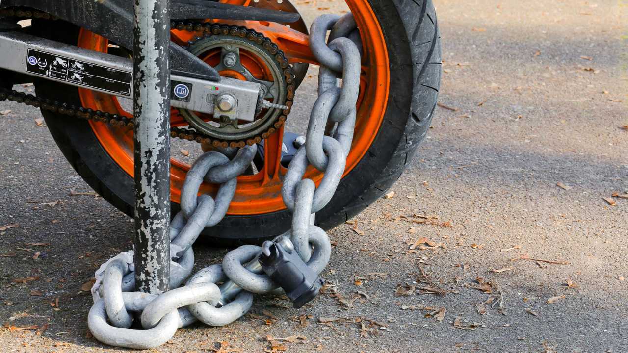 Motorcycle anti-theft chain with padlock on rear wheel