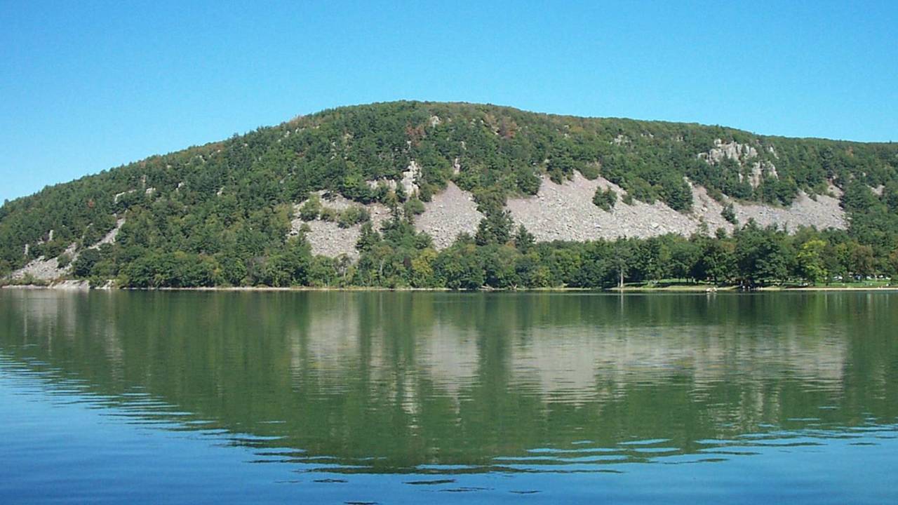 The 500 foot high quartzite cliffs of the Baraboo Range soar above Devil’s Lake.
