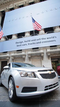 Passersby look on as General Motors' vehicles are displayed in front of the New York Stock Exchange on the morning of GM's initial public offering Thursday, November 18, 2010 in New York. 11/18/2010