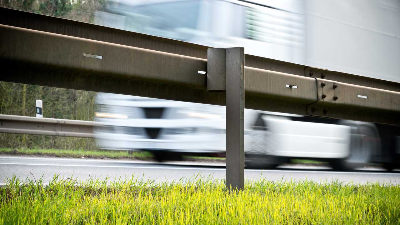 Roadside crash barrier with passing lorry