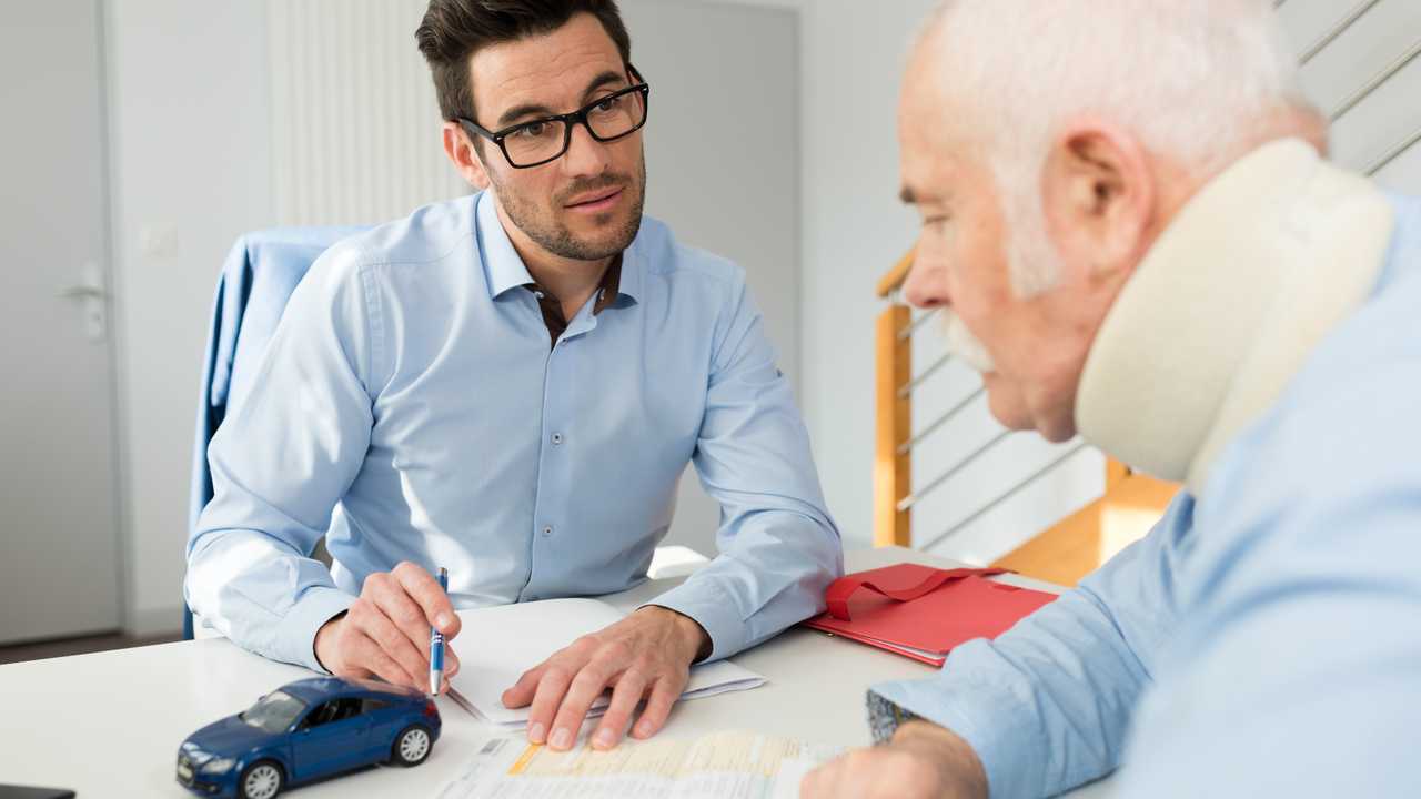 Personal injury lawyer in meeting with client wearing neck brace