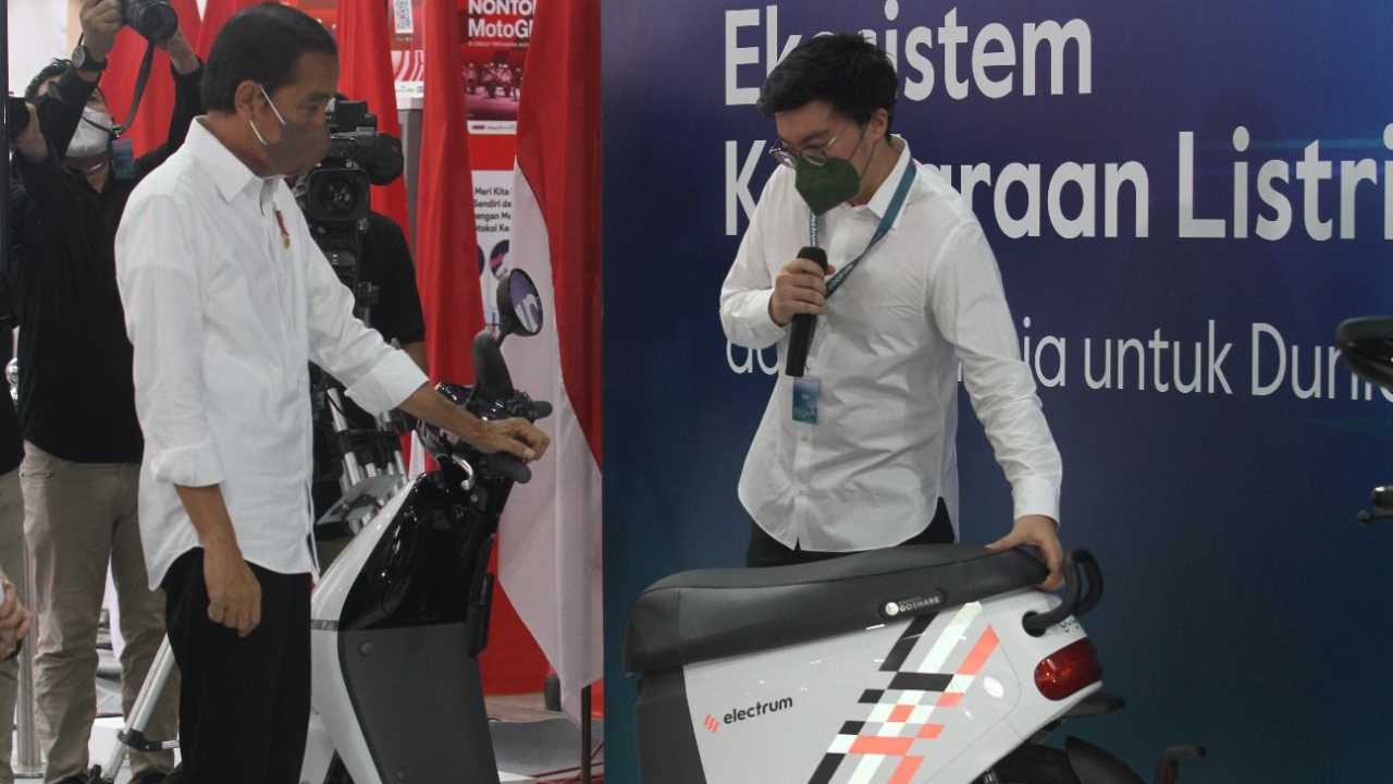 Presiden Joko Widodo (kiri) bertanya soal sepeda motor listrik dalam acara Sinergi EV.