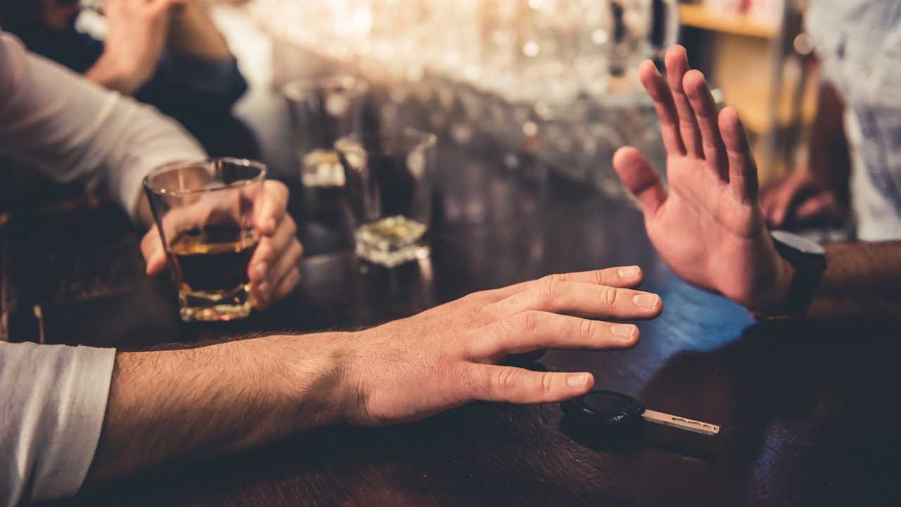 Drunk man taking car keys as bartender stops him