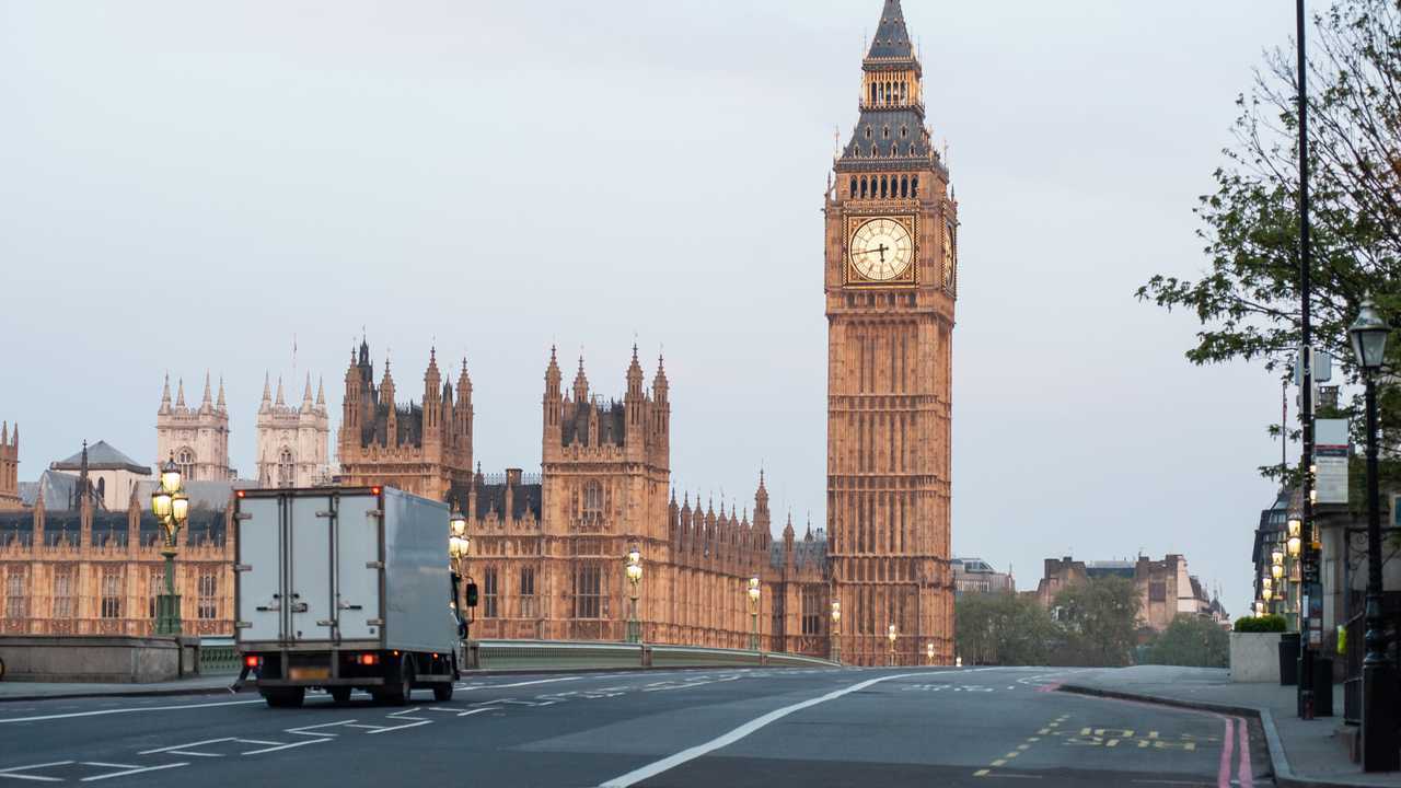 Delivery truck crosses Westminster Bridge with no traffic at dawn in London