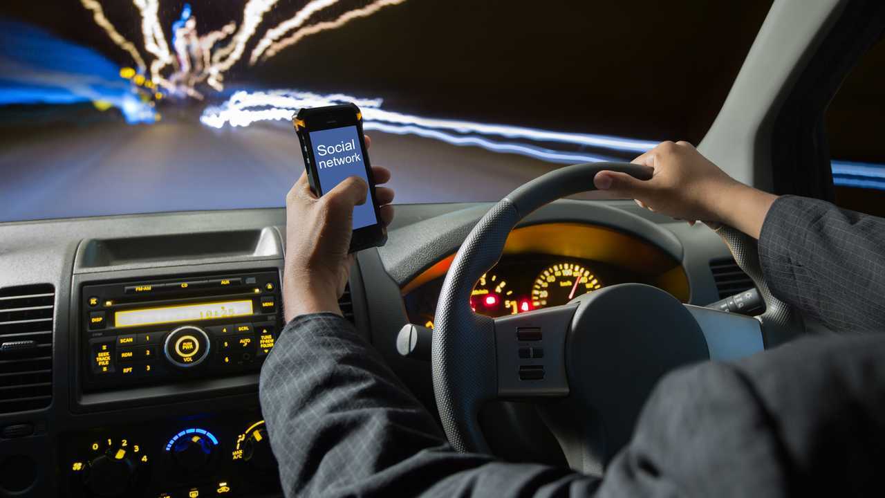 Man using smart phones while driving at night