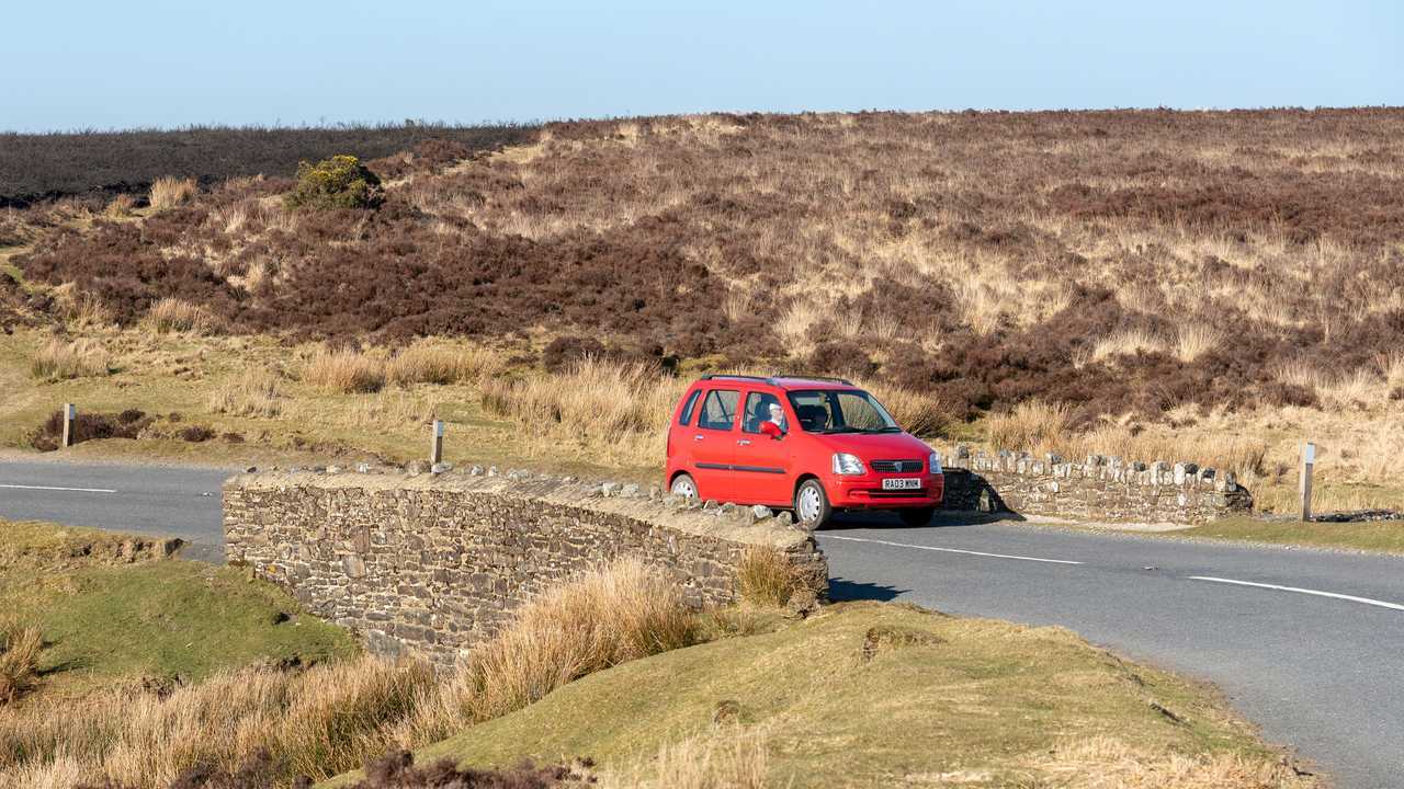 Car passing over a stone built bridge in Exmoor National Park England